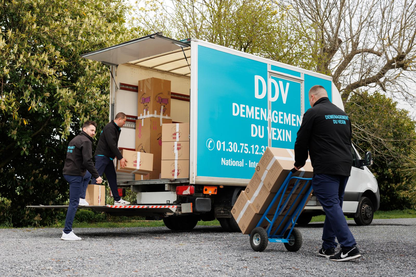 Deux déménageurs de la société Du Vexin Déménagement s'affairent à charger leur camion avec les biens d'un client pour un déménagement longue distance Deux déménageurs de la société Du Vexin Déménagement s'affairent à charger leur camion avec les biens d'un client pour un déménagement longue distance